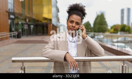 Serious young american woman lawyer talking on mobile phone, concept of a strong successful woman Stock Photo