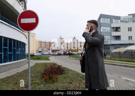 Man talking on the phone next to a parking lot Stock Photo