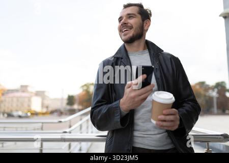 A man with a mobile phone in the city drinking coffee Stock Photo