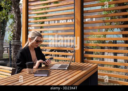 Woman working on a laptop in the city in a cafe Stock Photo
