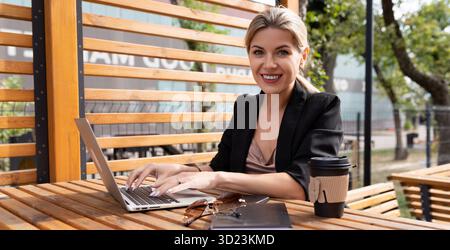 Portrait of a young woman working on laptops in the park Stock Photo