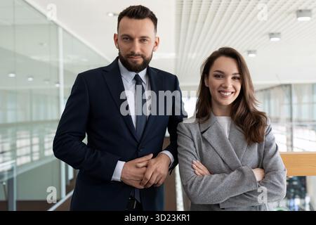 Heterosexual company executives in business suits against the backdrop of a modern stylish office, concept of banking services Stock Photo