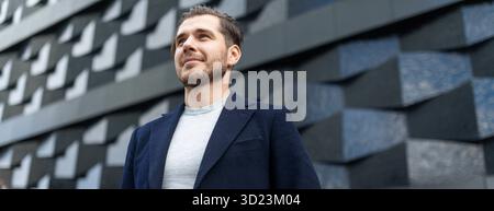 Close-up portrait of a serious businessman against the background of the texture wall of the building Stock Photo