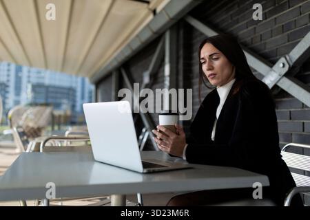 Mature businesswoman working in a cafe with a laptop Stock Photo