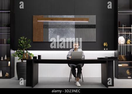 Business woman head of the office sitting Behind an expensive furniture office desk working on a laptop Stock Photo