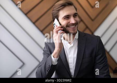 Confident man businessman in a jacket speaks on the phone in the office Stock Photo