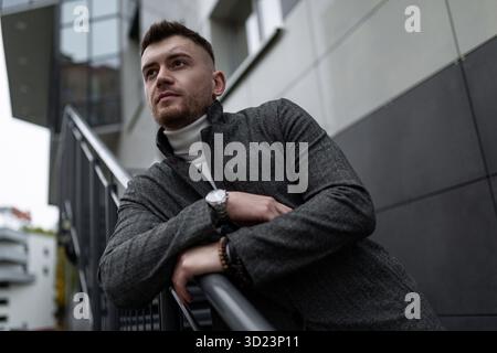 Portrait of a brutal young man on the stairs near the office Stock Photo