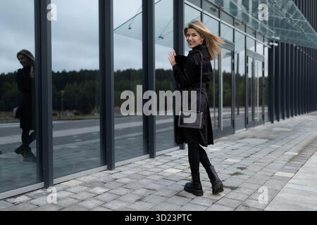 Portrait of a female office worker against the backdrop of a glass skyscraper Stock Photo