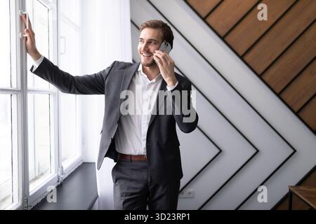 Business man talking on the phone in the office by the window Stock Photo