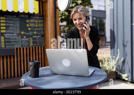 Young successful woman working on cafe laptop Stock Photo