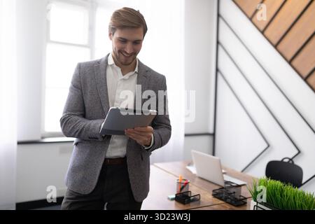 Business man with a tablet in his hands IN A STYLISH OFFICE Stock Photo