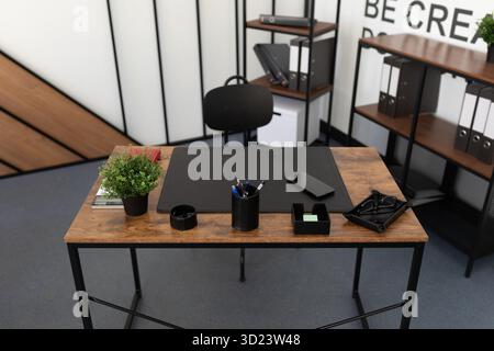 Office desk in an empty office with office supplies and a leather pad Stock Photo