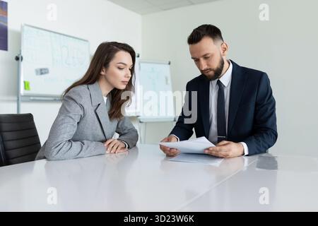 Farm workers studying a document sitting at a table in a meeting room Stock Photo