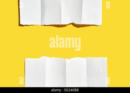 Two torn pieces of white paper on bright yellow background creating minimalist Stock Photo