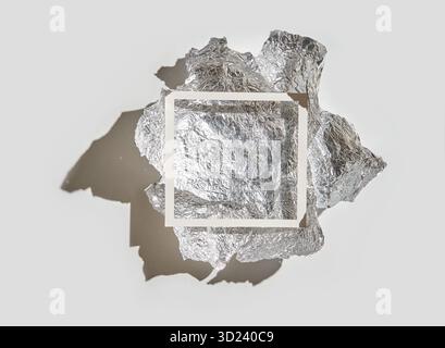 Crumpled aluminum foil against gray background with shadowed light effect Stock Photo