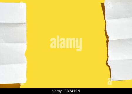 Torn white paper strips on bright yellow background creating contrasting Stock Photo