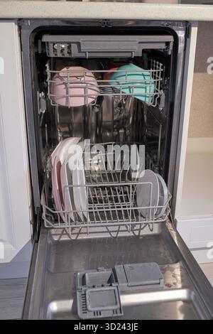 Open dishwasher with clean dishes and bowls in modern kitchen interior Stock Photo