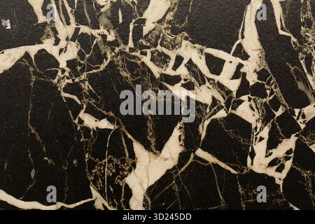 Beautiful black marble surface with white and gold veining patterns showcasing natural elegance and timeless design Stock Photo