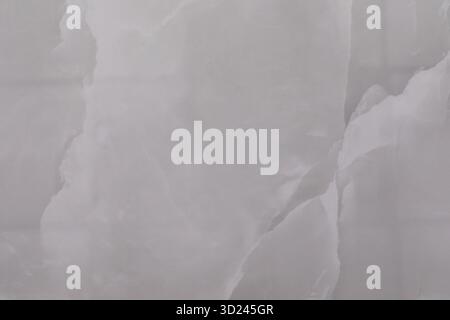 Large smooth surface of white marble with natural veins and patterns visible on a bright day in a minimalist space Stock Photo