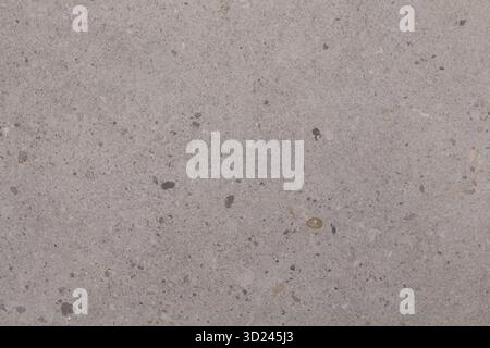 Light gray concrete surface with small stones and textures showing natural patterns and variations in color Stock Photo