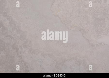 Waves crashing on a sandy beach at sunset creating patterns and textures in the sand Stock Photo