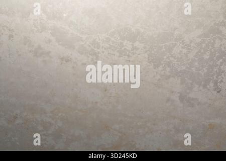 Smooth, textured surface of light gray stone with subtle variations in color and pattern visible under soft light conditions Stock Photo