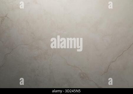 Smooth beige marble surface with subtle texture and veining patterns in natural lighting Stock Photo