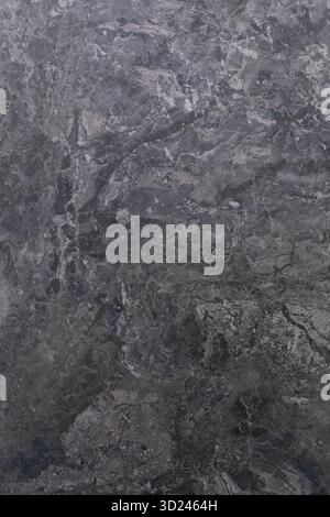 Dark gray textured stone surface with natural patterns and variations in shade for design and decor Stock Photo