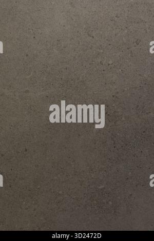 Gray textured surface with subtle variations reflecting light in an indoor setting Stock Photo