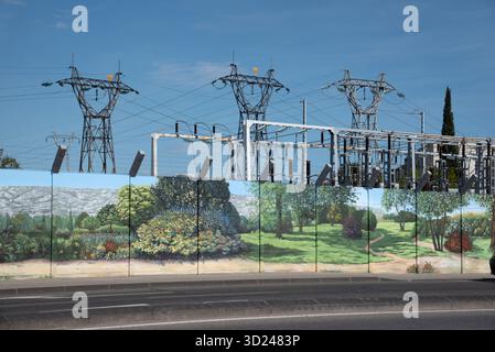 Electricity Substation or Switchyard with Electric Pylons, Transformers and Decorated or Painted Security fence or Safety Fence Stock Photo