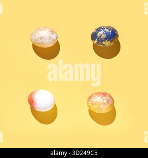 Four colorful dyed easter eggs on yellow background with shadows in bright Stock Photo