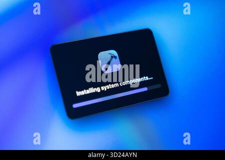 Poznan, Poland - September 18, 2025: Modern screen shows an application window with 'Installing system components' and a progress bar, signifying cruc Stock Photo