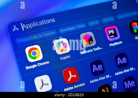 Poznan, Poland - September 18, 2025: Applications interface on a vibrant blue digital display, showing categorized software for business, development, Stock Photo