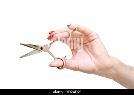 Caucasian female hand holding small scissors with red manicured nails on white Stock Photo