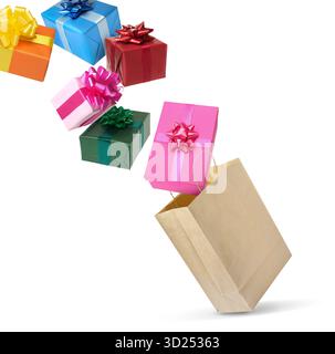 Many gift boxes falling into paper bag on white background Stock Photo