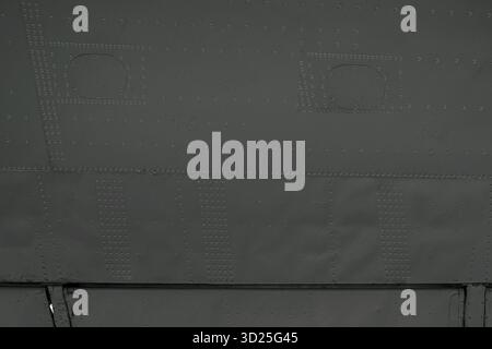 Gray skin of an old aircraft.Aircraft wing surface with aileron. Gray metal skin with rivets of the aircraft. A close-up of an airplane wing aileron Stock Photo