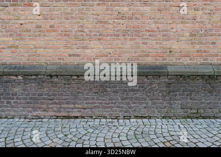 Exterior view of old church pale and dark red brick wall with cobblestone sidewalk Stock Photo