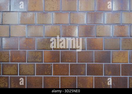 A textured brown brick wall with a rustic and weathered appearance Stock Photo