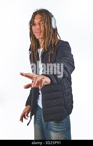 Young black man wearing dreadlocks and headphones striking a pose against a white background Stock Photo
