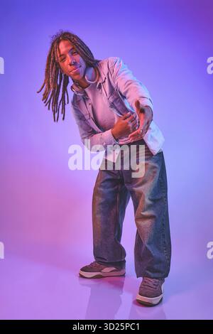 Young man with dreadlocks reaching out wearing Stock Photo