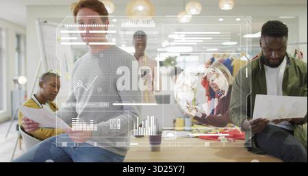 Gathering design team reviewing charts, data overlays on wooden table in design studio, with tablet Stock Photo