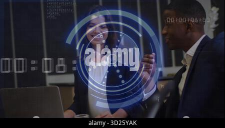 Reviewing sales data, executives collaborating at office desk in suits with laptop, HUD overlay Stock Photo