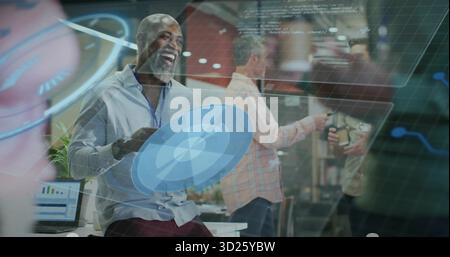 Holding shield, man in blue shirt leaning on desk at office, with floating data overlays Stock Photo