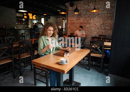 Freelancer is working at cafe using laptop and smartphone Stock Photo