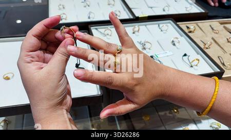 choosing rings at jeweler closeup of gold bands and diamond centerpiece Stock Photo