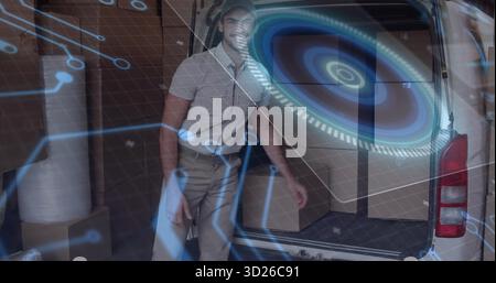 Uniformed delivery driver grabbing boxes in loading bay, with cargo van, holographic overlay Stock Photo