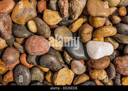 Artistic pebbles beach top closeup view, natural stone texture pattern background, minimalist coastal nature abstract Stock Photo