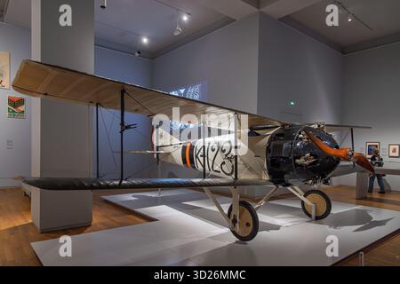 A preserved First World War fighter plane, designed by Frits Koolhoven, is showcased in a museum setting on a raised white platform with wooden floors Stock Photo