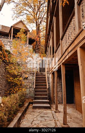An old vintage building with a staircase leading up to it. The staircase is made of wood and is surrounded by a brick wall. The building has a rustic Stock Photo