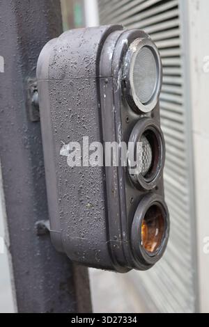 Weathered metal traffic light in France with lower yellow light on Stock Photo